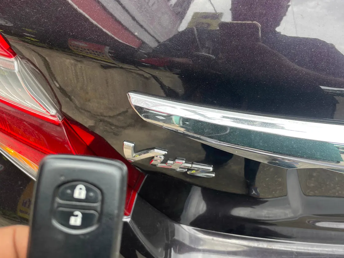 Two-button remote beside a Toyota Vitz